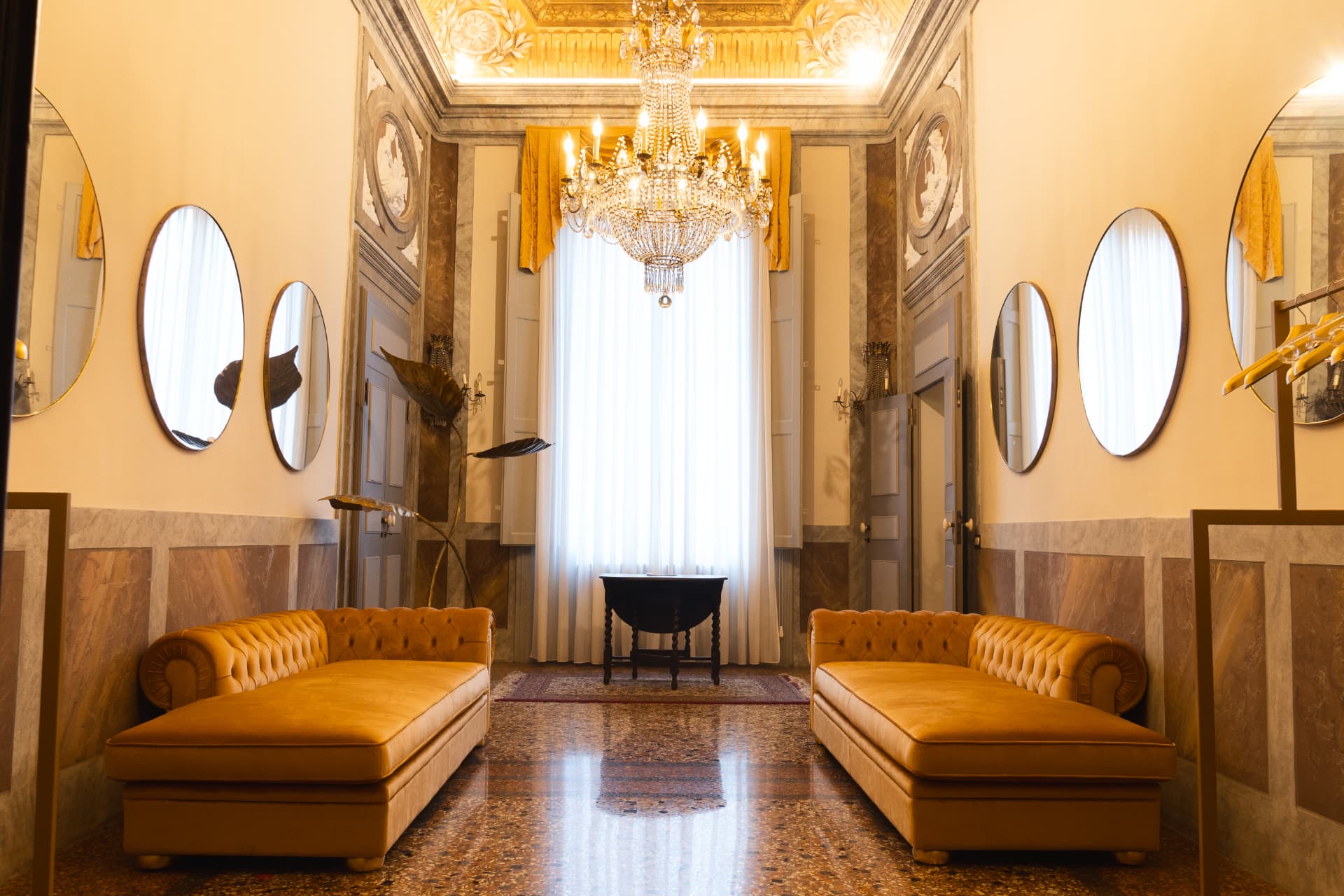 Salotto di Palazzo Savioli con divani in velluto e specchi